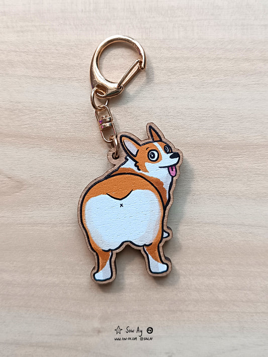 un corgi de dos, on voit ses fesses en premier plan et il nous regarde avec les yeux écarquillés et la langue dehors