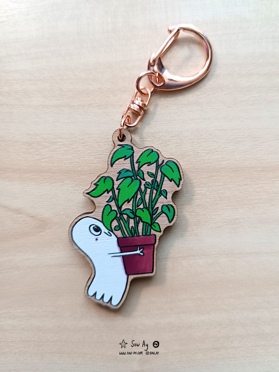 petit fantôme heureux, de profil en train de porter une plante verte bien plus grande que lui