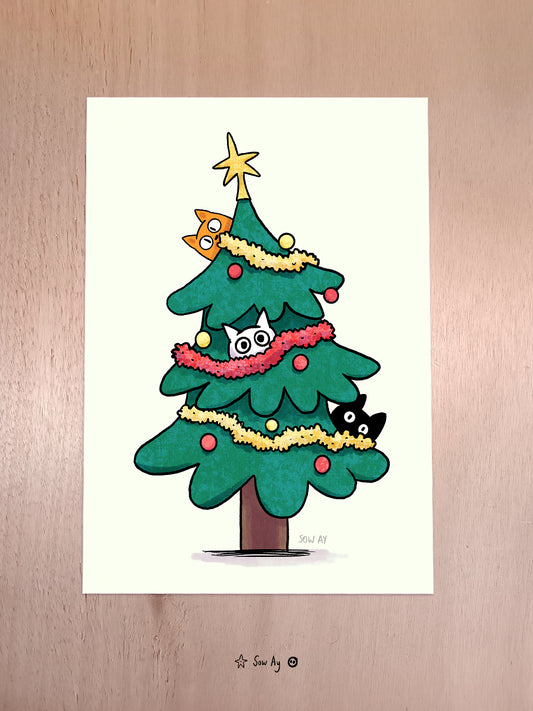 un sapin de noël décoré dans lequel trônent 3 petits chats cachés qui regardent fixement.