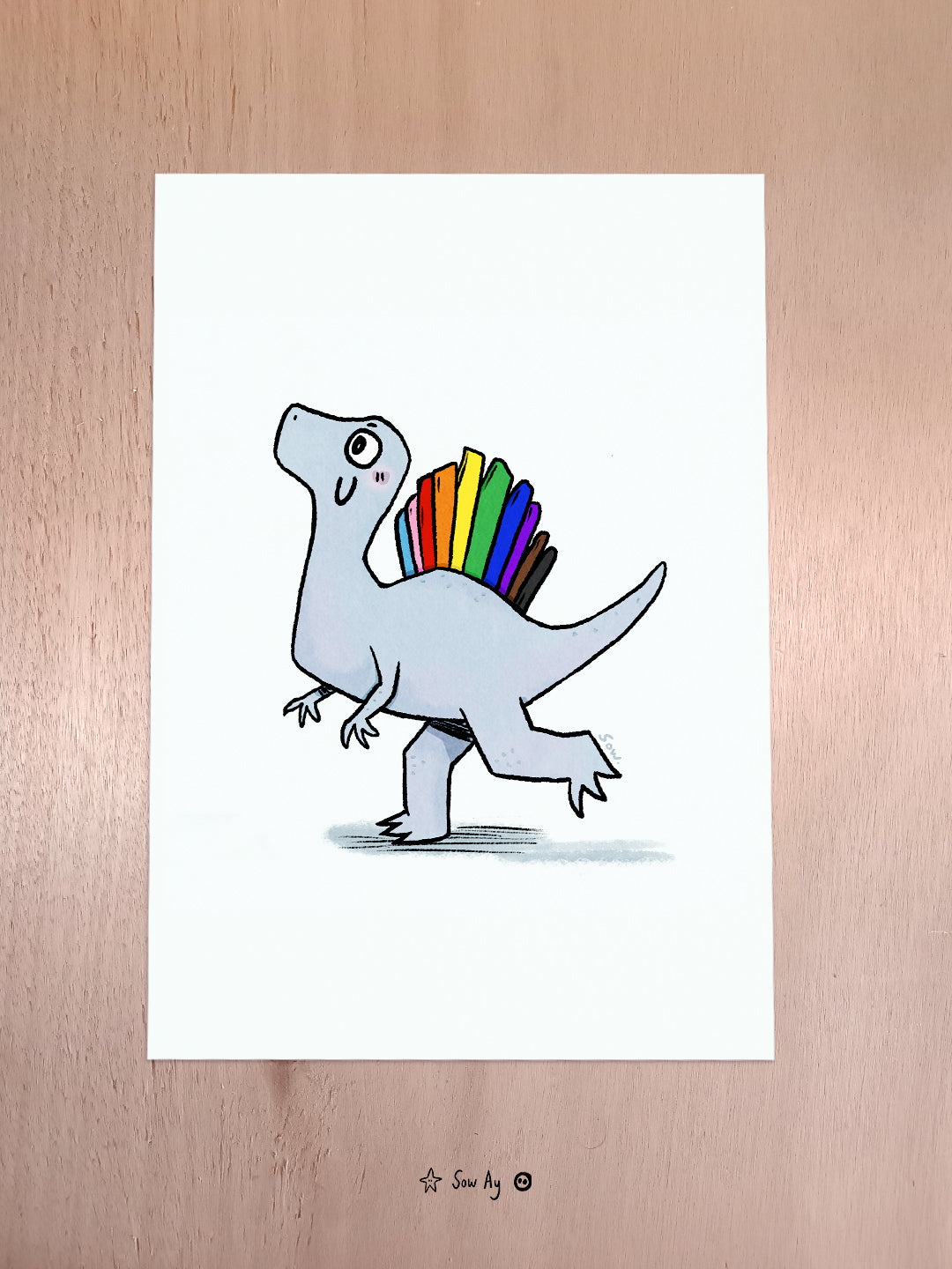 Spinosaure en version mignonne sur fond blanc, il est gris mais la crête sur son dos est aux couleurs du drapeau LGBTQIA+
