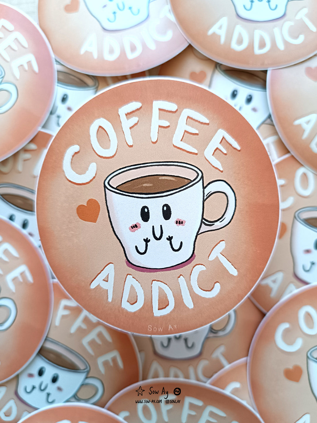 une petite tasse à café, toute contente et rougissante. Autour d'elle est écrit "coffee addict"