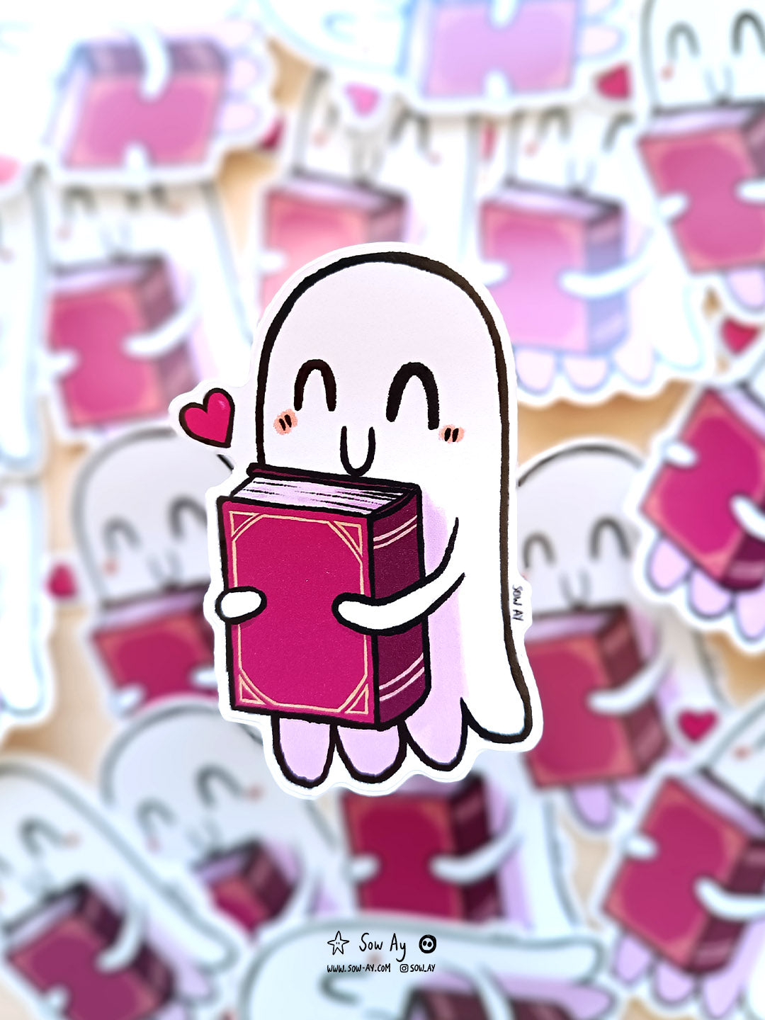 petit fantôme tout content qui tient contre lui un grand livre rouge