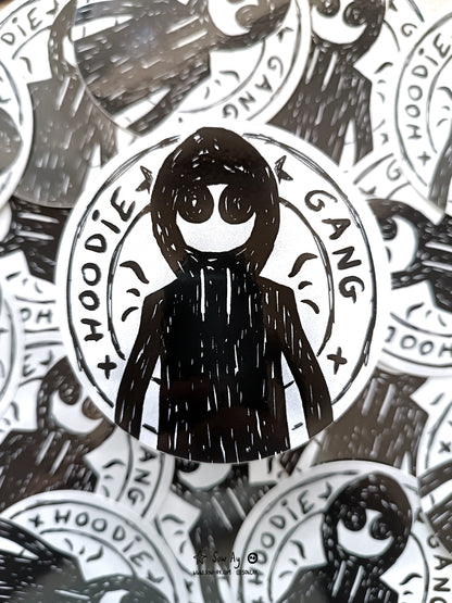 personnage de face avec un sweat shirt à capuche et de grands yeux. Autour de lui est inscrit : hoodie gang